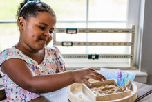 Load image into Gallery viewer, Little girl using the sand writing tray to practice writing her numbers using the 1-12 Ocean Adventure Number Cards.