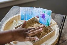 Load image into Gallery viewer, This preschooler is practicing writing numbers using the included writing tray with sand filler and Sea Creature Number Cards #1-12.