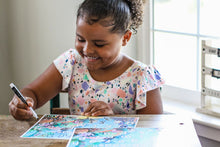 Load image into Gallery viewer, Little girl smiling and tracing the letters on the Under the Sea "AB-Seas" Mat.