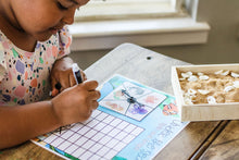 Load image into Gallery viewer, Little Learner filling out the graph on the Under the Sea "Spin and Graph" game.