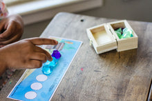 Load image into Gallery viewer, Child building her pattern with resin gems.
